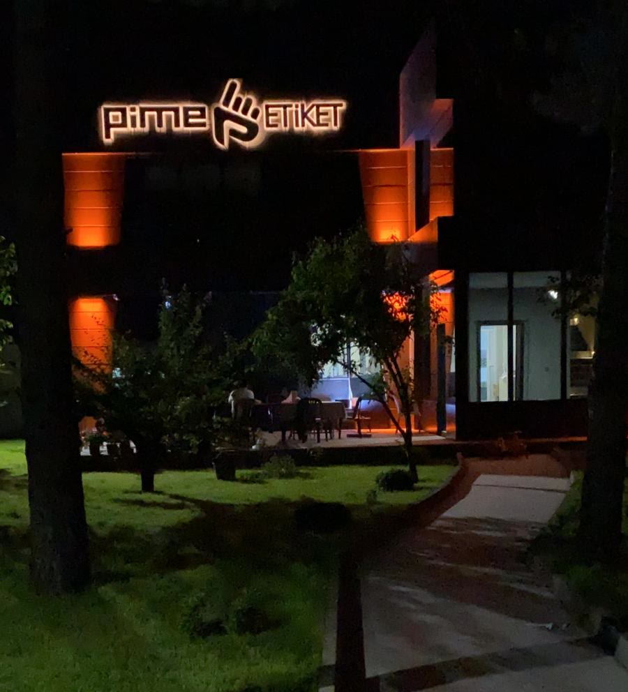 Pime factory entrance with illuminated sign at night